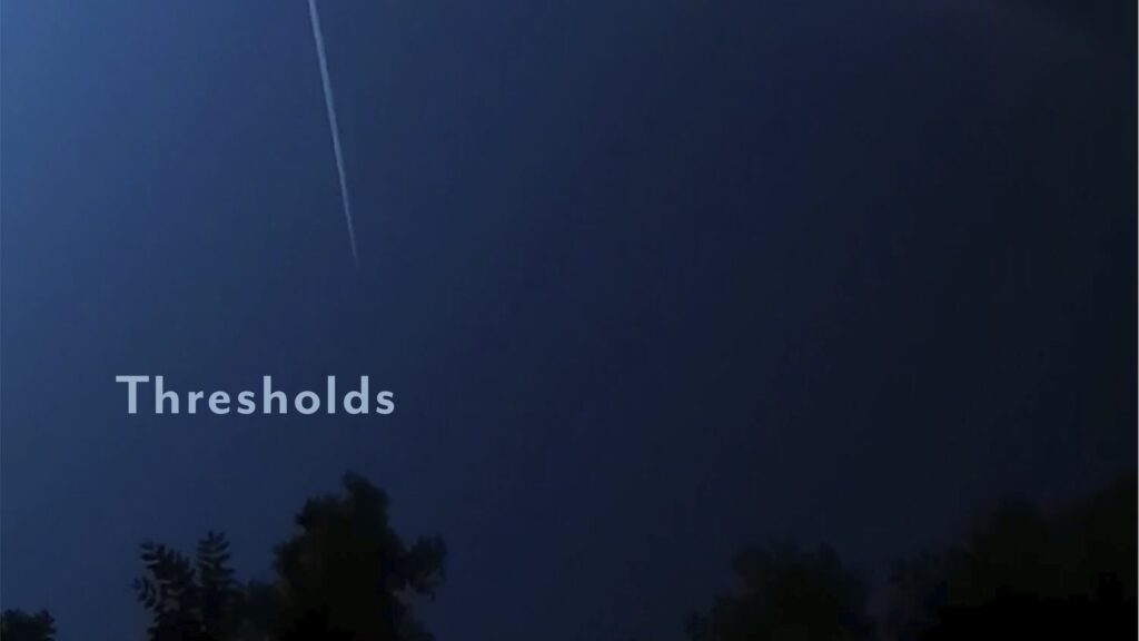 A blue night sky with a contrail